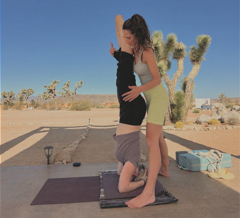 Stephania adjusting a student during a private session in the desert